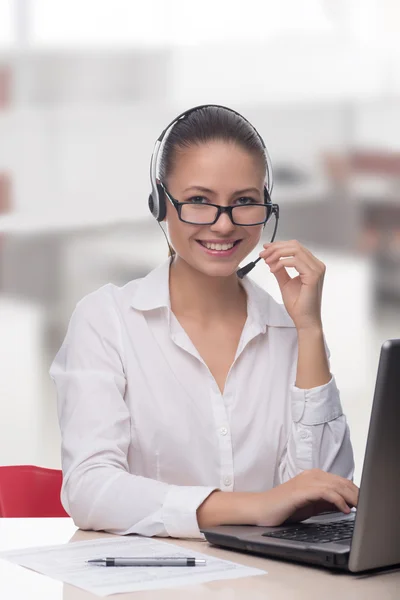 Mujer de negocios hablando por teléfono mientras trabaja en su computadora en la oficina — Foto de Stock