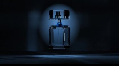 Siyah arka planda bir şişe parfüm döner ve yakıcı ışıldar.. 