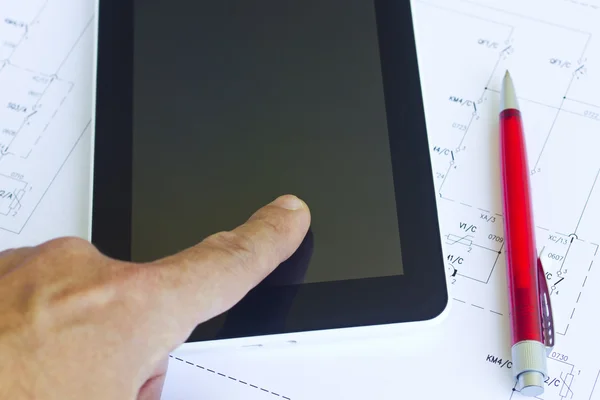 Man aan het werk met tablet over engineering diagram Rechtenvrije Stockafbeeldingen