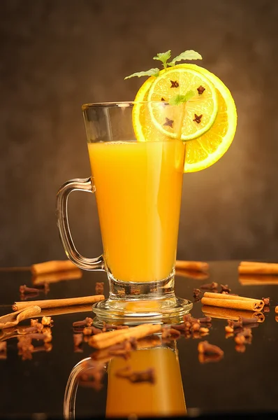 Zumo de naranja caliente en taza de vidrio y especias —  Fotos de Stock