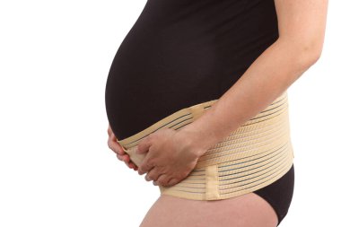 Belly of pregnant woman with elastic maternity band on white isolated background