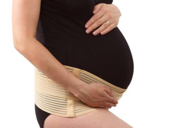 Belly of pregnant woman with elastic maternity band on white isolated background