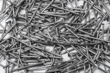 The pile of metal nails lies on the white background.