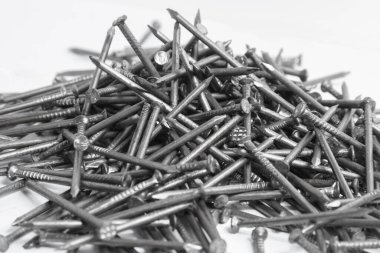 The pile of metal nails lies on the white background.