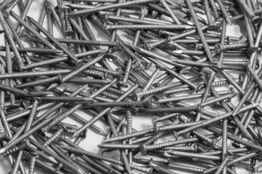 The pile of metal nails lies on the white background.