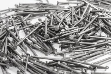 The pile of metal nails lies on the white background.