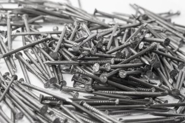 The pile of metal nails lies on the white background.
