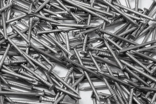 The pile of metal nails lies on the white background.