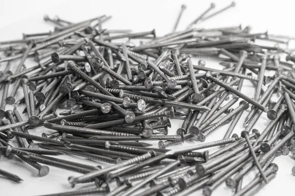 The pile of metal nails lies on the white background.