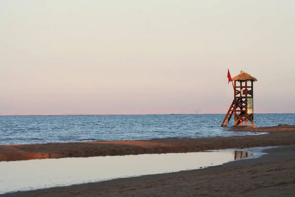 Rescue tower on the beach. Rescue post on the sea coast. Red flag on the rescue tower.