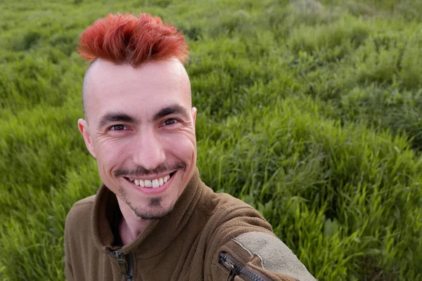 Smiling man with red hair. Smiling man in military uniform.