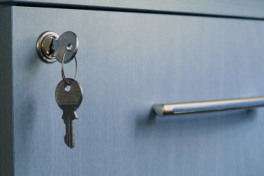 The key in the keyhole of the desk drawer