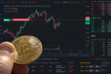 Golden bitcoin and stock chart background. Image of bitcoin against market price chart as blur background