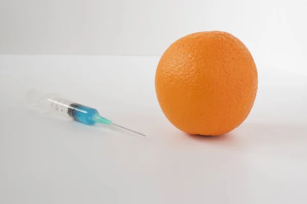 Injecting Blue Liquid Orange Fruit Syringe Blue Liquid White Background — Φωτογραφία Αρχείου