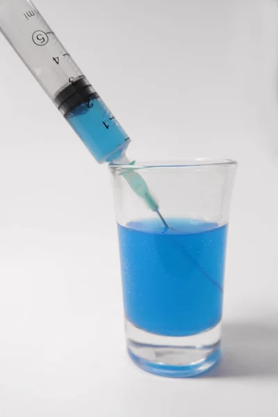 Virus vaccine. Filling a syringe with a blue solution. 