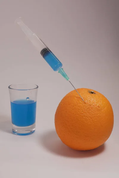 Injecting Blue Liquid Orange Fruit Orange Syringe Glass White Background — Φωτογραφία Αρχείου