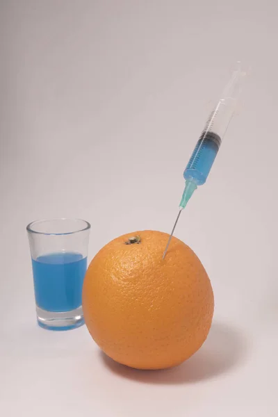 Injecting Blue Liquid Orange Fruit Orange Syringe Glass White Background — Stok fotoğraf