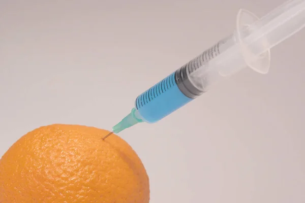 Injecting Blue Liquid Orange Fruit Syringe Blue Liquid White Background — Foto de Stock