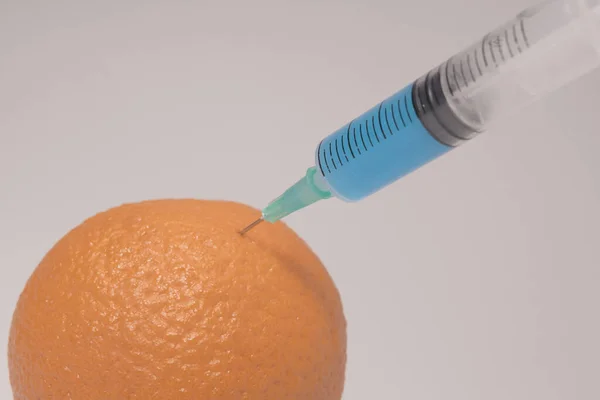 Injecting Blue Liquid Orange Fruit Syringe Blue Liquid White Background — Stok fotoğraf