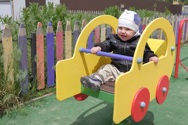Kid in the playground. Little boy in the black jacket. The boy in the leather jacket