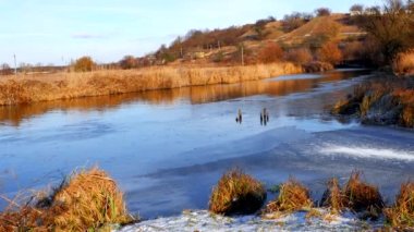 First frosts. The river starts to ice. Winter river. Rural landscape. Cold mountain river.