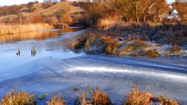 First frosts. The river starts to ice. Winter river. Rural landscape. Cold mountain river.