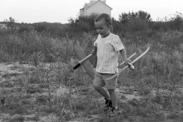 Monochrome photo. Little boy launches toy airplanes. Young aviator. The boy dreams of becoming an airplane pilot.