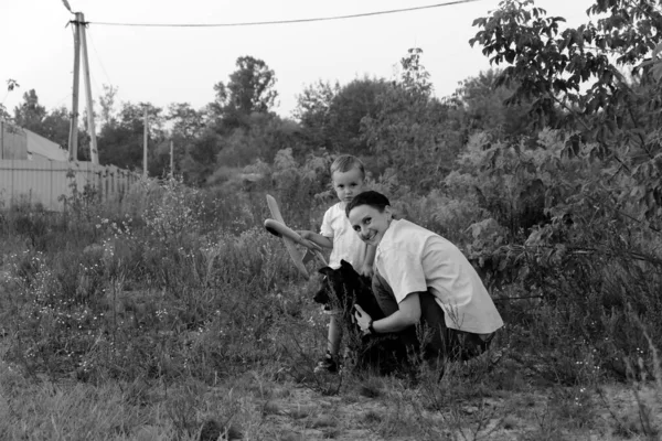 Monochrome photo. Mother with son and dog. A little boy and his mother are walking the dog. Happy family on a walk.