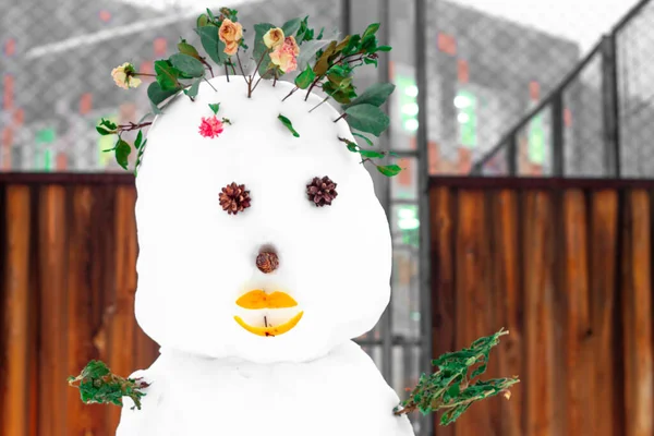 Saç yerine gerçek güller, ağız yerine portakal kabukları ve konilerden yapılmış gözler, oyun parkında çocukların yaratıcılığı ve bahar beklentileri olan sıra dışı yaratıcı bir kardan adam.