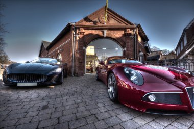 2 Sport cars parked parked outside a building clipart