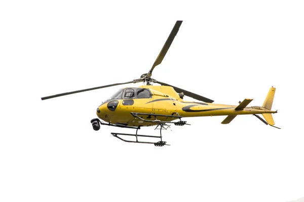 Κίτρινο ελικόπτερο με μια φωτογραφική μηχανή κατά την πτήση Royalty Free Φωτογραφίες Αρχείου