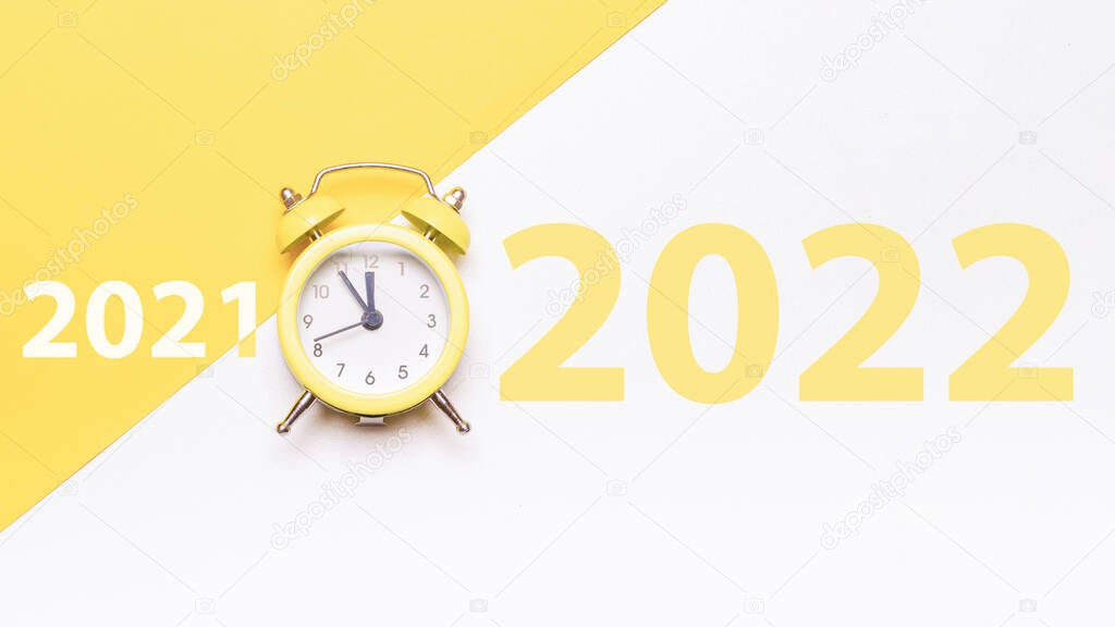 Midnight new years 2022. Retro style yellow clock in happy Christmas midnight. Countdown to new year on happy xmas yellow background. Last moments before Christmas or New Year