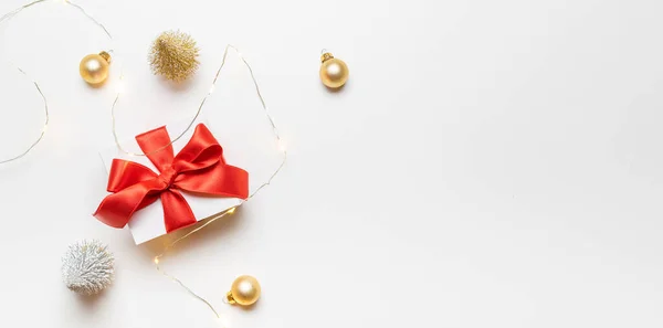 礼物的背景 白色礼品盒 红色缎带 新年球和闪光的灯饰 圣诞构图白色背景贺卡 平面布局 顶视图 复制空间 — 图库照片