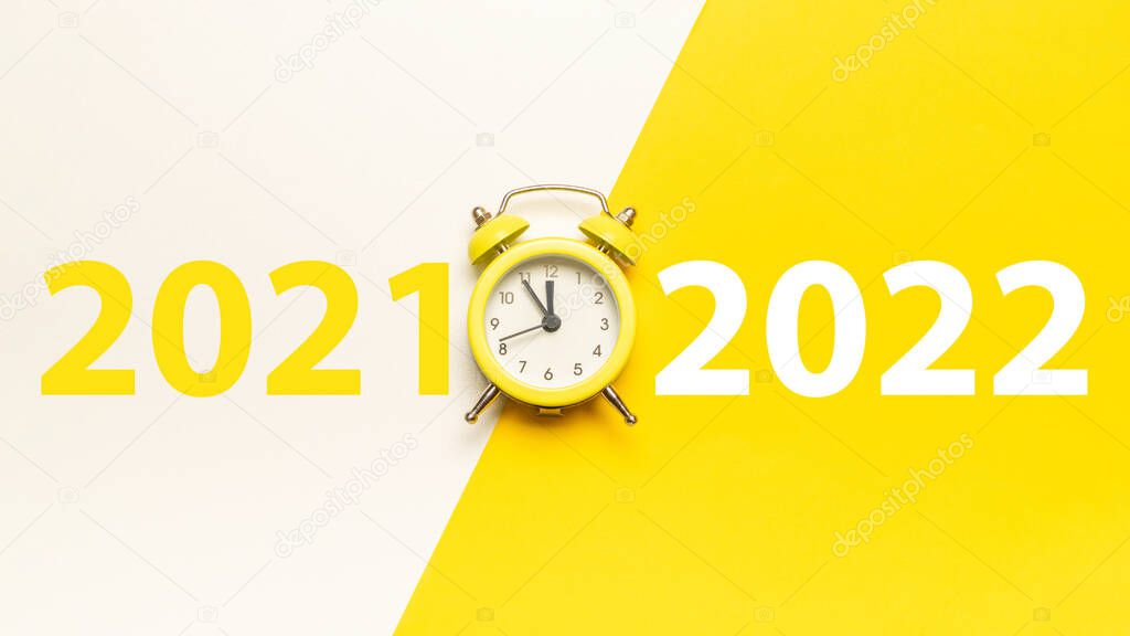 Midnight new years 2022. Retro style yellow clock in happy Christmas midnight. Countdown to new year on happy xmas yellow background. Last moments before Christmas or New Year