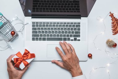 Xmas online alışveriş. Hediye kutusu kırmızı kurdele, tramvay ve dizüstü bilgisayar, düz bir internet alışveriş kompozisyonu. Noel mağazası, üst manzara.
