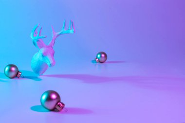 Noel hayvanı neon kış arka planı. Neon gradyan arka planda tatili süsleyen değerli bir top. Asgari soyut xmas ren geyiği. Mutlu yıllar kopyalama alanı
