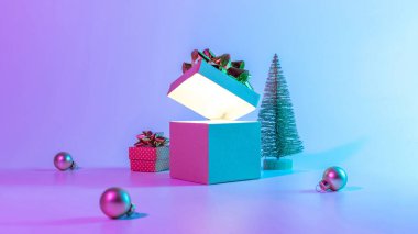 Neon xmas kış geçmişi. Parlak ışıklı Noel hediye kutusunu aç, en az ağaçla. Neon soyut gradyan arkaplan üzerinde bayram süsleme takısı topu. Mutlu yıllar kopyalama alanı