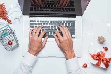 Tatil çevrimiçi alışveriş. Hediye kutusu kırmızı kurdele, tramvay ve dizüstü bilgisayar, düz konumda internet alışveriş kompozisyonu. Mutlu Noeller ve mutlu yıllar.