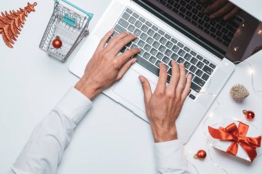 Noel çevrimiçi mağazası. Hediye kutusu kırmızı kurdele, tramvay ve dizüstü bilgisayar, düz konumda internet alışveriş kompozisyonu. Xmas mağazası, üst manzara