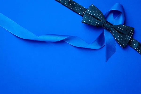 蓝色前列腺带11月对男性前列腺癌的认识。蓝色缎带,深蓝色背景的流行领带.十一月及国际男士日. — 图库照片