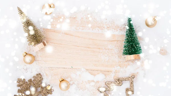 Vánoční podkladový stůl. Zimní dřevěné dekorace na pozadí. Vánoční prkno se starou rustikální zdí, bílým zmrzlým sněhem, zlatými koulemi a dárkovou krabicí. Minimální rozloha. — Stock fotografie