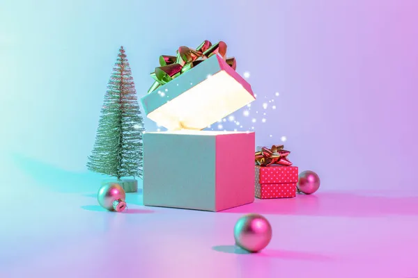 ネオンクリスマス冬の背景 輝きのライト 最小限の木とXmasのギフトボックスを開きます ネオン抽象的なグラデーションの背景に休日の装飾バブルボール ハッピーニューイヤーコピースペース — ストック写真
