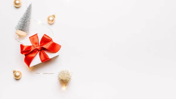 冬季背景黄金 白色礼物 红色蝴蝶结 金球和闪光的灯饰圣诞装饰白色背景的贺卡 冬季节庆作文 有复制空间 — 图库照片