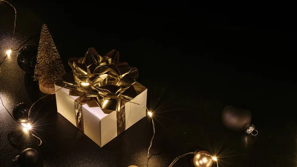 Świąteczna Kompozycja Białe Pudełko Złotą Wstążką Kulki Noworoczne Błyszczące Lampki — Zdjęcie stockowe