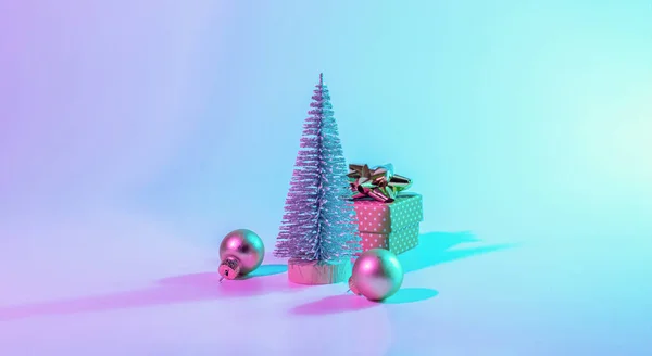 ネオンクリスマス冬の背景 最小限の抽象的な木 Xmasギフトボックス ネオングラデーションの背景に休日の装飾バブルボール ハッピーニューイヤーコピースペース — ストック写真