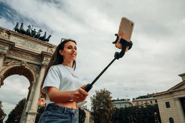 Gezginler Milan adasını etkiliyor. Avrupa 'da boyama evi Milano' da. Piazza del Duomo, Katedral Meydanı 'nda akıllı telefonlu fotoğrafçı kız. Seyahat ve serbest çalışma, modern yaşam tarzı.
