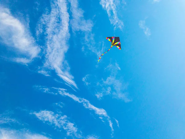 风筝的天空 色彩艳丽的飞行玩具 空气风筝在蓝风的背景下飞行 夏日云彩中的彩虹风筝 童年的概念 — 图库照片