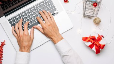 Çevrimiçi. Noel için hediye kutusu kırmızı kurdele, tramvay ve dizüstü bilgisayar, düz konumda internet alışveriş kompozisyonu. Noel satışları ve indirimler