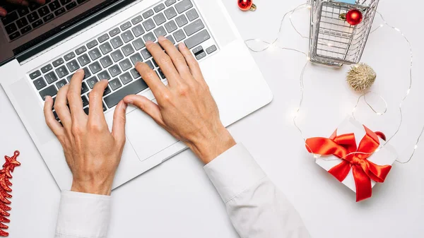 Çevrimiçi. Noel için hediye kutusu kırmızı kurdele, tramvay ve dizüstü bilgisayar, düz konumda internet alışveriş kompozisyonu. Noel satışları ve indirimler