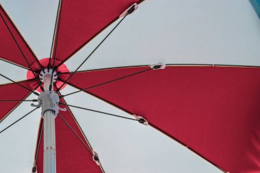 Şemsiye plajı. Mavi deniz arka planında kızıl yaz plajı şemsiyesi. Tatil için güneş kremi. Açık hava tatilini okyanusta fotokopi alanı ile rahatlat